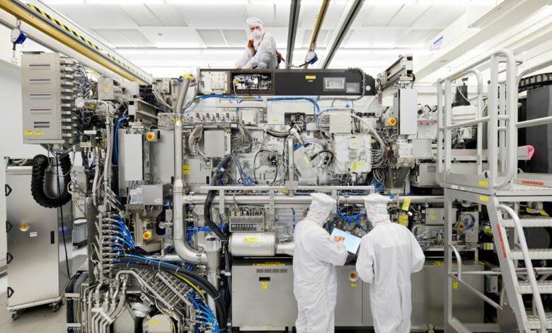 Employees are seen working on the final assembly of ASML