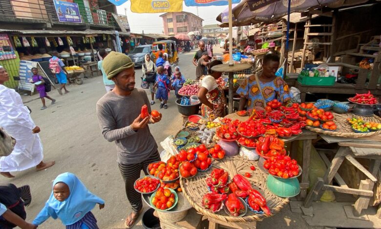 Nigerian artist Olufela Omokeko buys fresh pepper at a food market in Lagos
