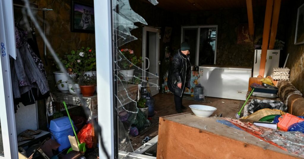 A local is seen in a window her house destroyed by a Russian military strike in the village of Stepne, in Zaporizhzhia Region