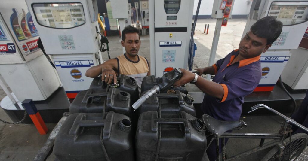 A worker prepares to fill a jerry-can at a fuel station in Kolkata