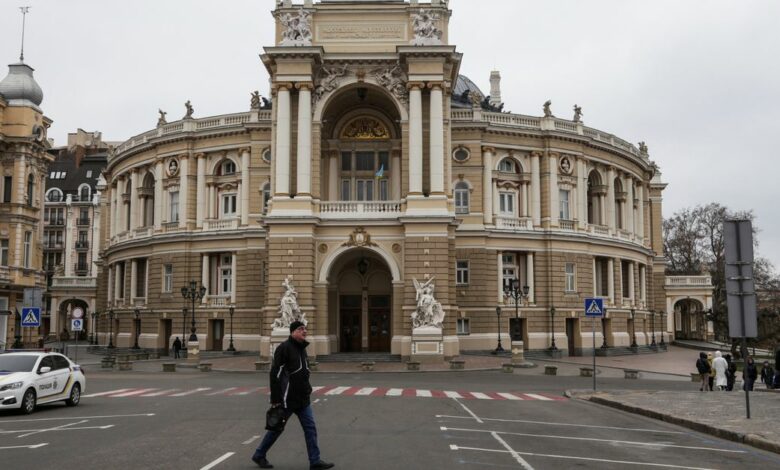 A man walks next to the Opera Theatre building in the city centre of Odesa