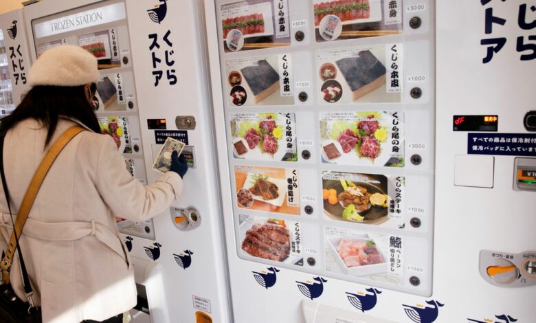 A customer buys whale meat on the opening day of the shop by a Japanese whale-hunting company with vending machines in Yokohama
