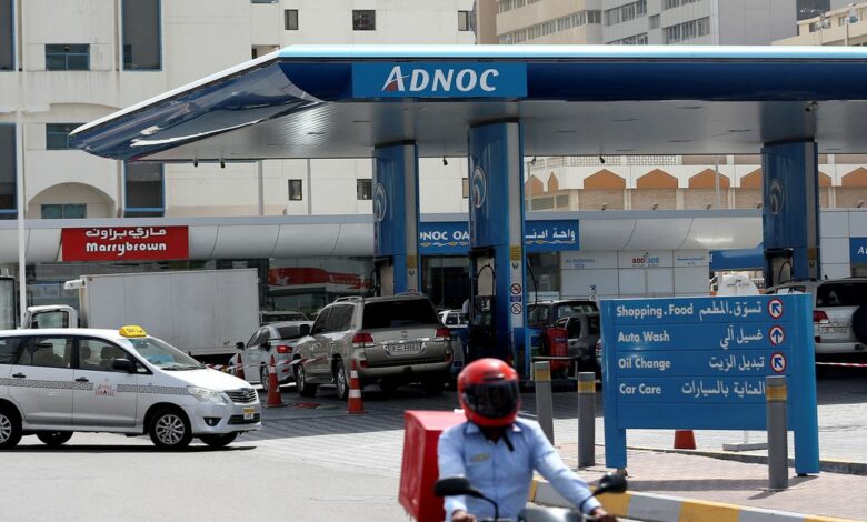 Man rides a motorcycle near an ADNOC petrol station in Abu Dhabi