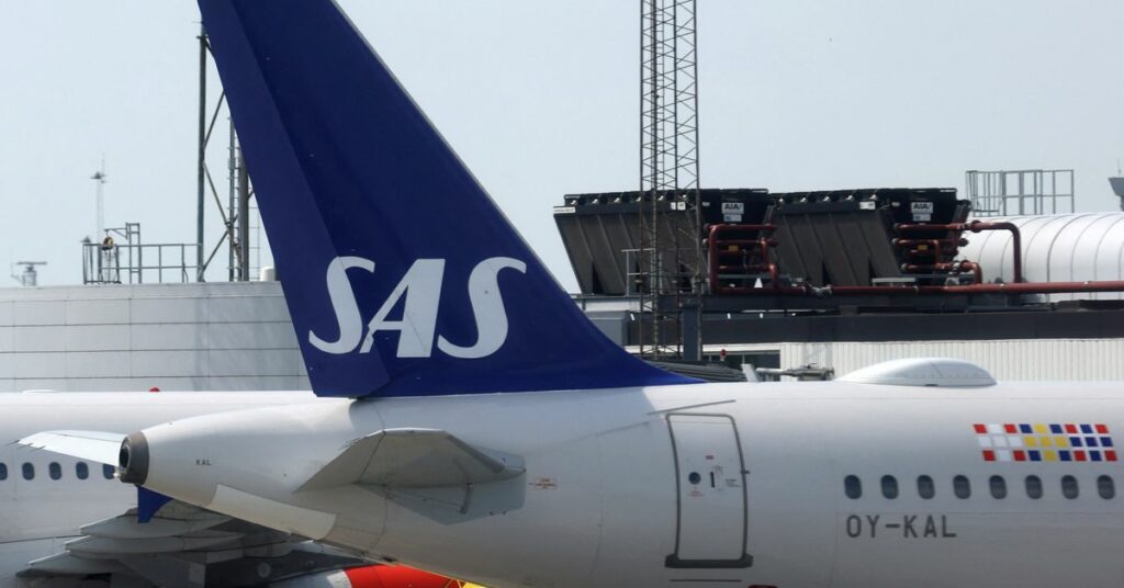 The tail fin of a Scandinavian Airlines (SAS) airplane parked on the tarmac at Copenhagen Airport Kastrup in Copenhagen
