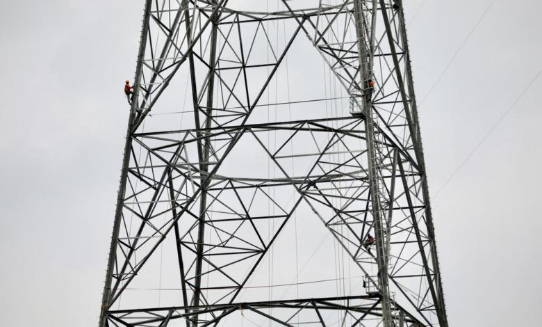 A worker climbs an under construction power transmission tower in Munshiganj, Bangladesh