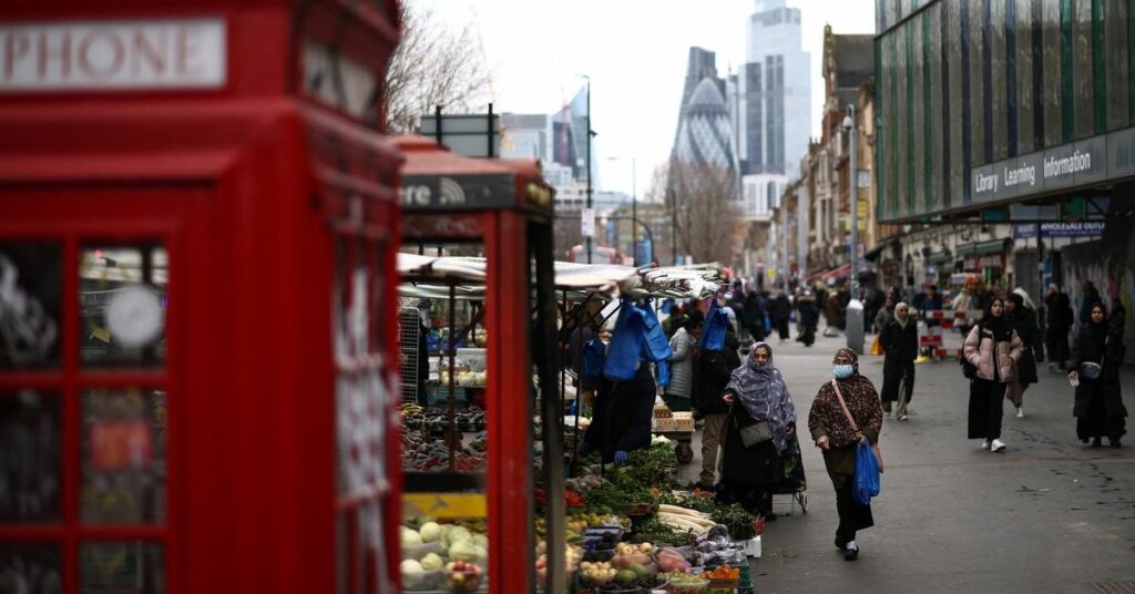 People browse stalls at a street market in east London