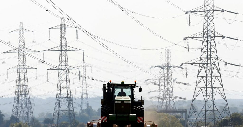 A farmer works in a field surrounded by electricity pylons in Ratcliffe-on-Soar