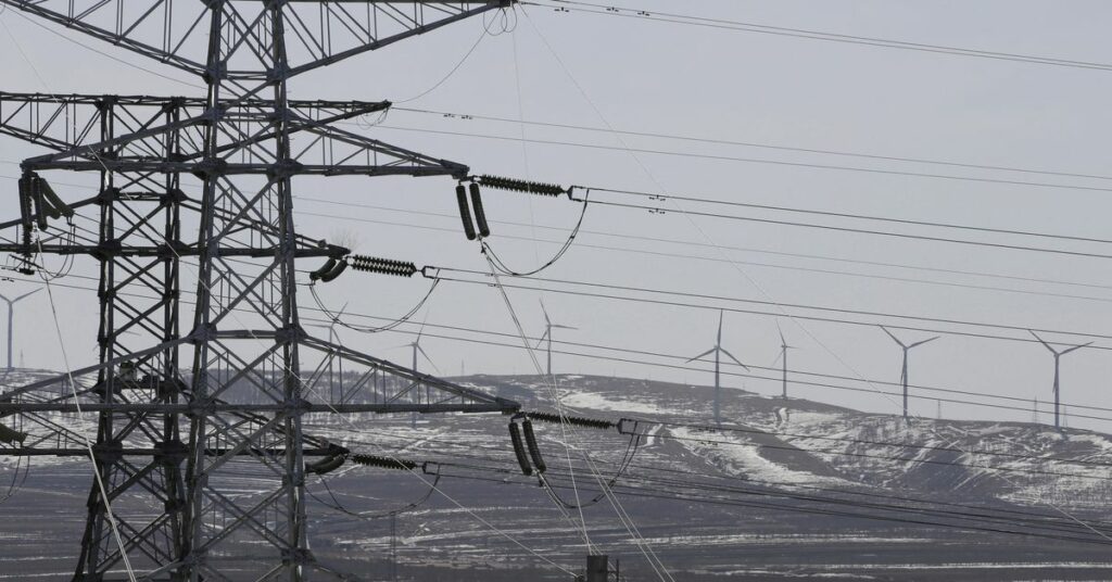 Power lines and wind turbines are pictured at a wind and solar energy storage and transmission power station in Zhangjiakou