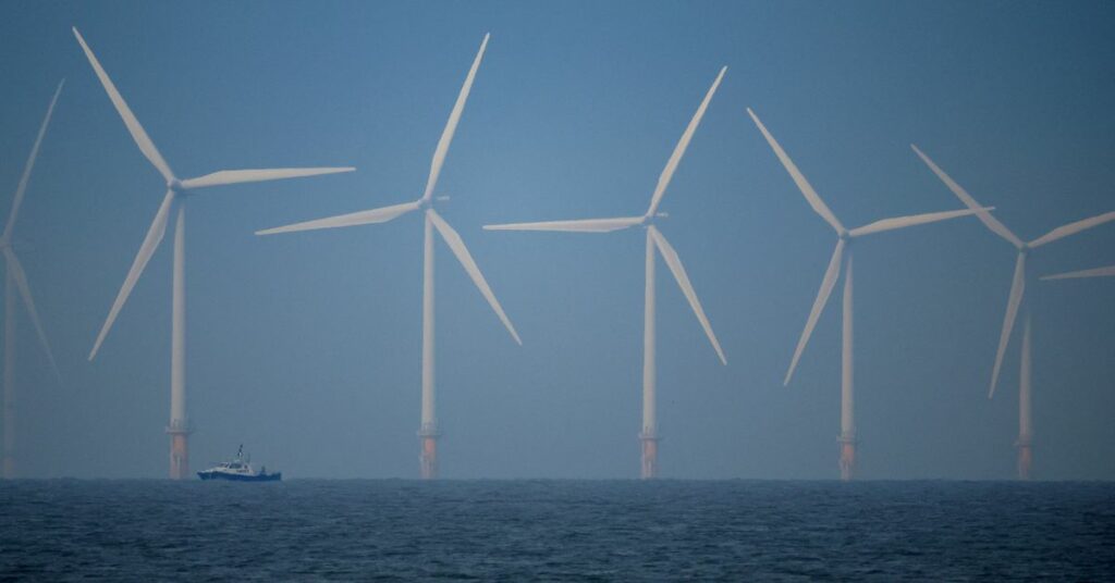 A survey vessel sails past wind turbines at the Burbo Bank offshore wind farm near New Brighton