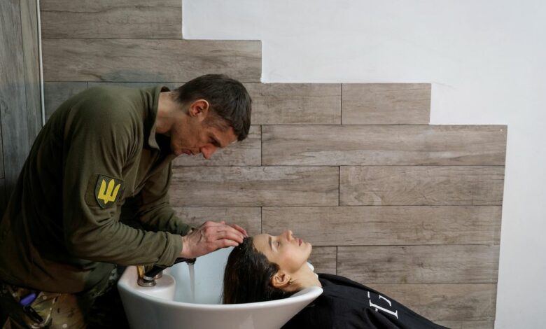 Hairdresser and Ukrainian Territorial Defence unit volunteer works at a beauty salon, in Kyiv