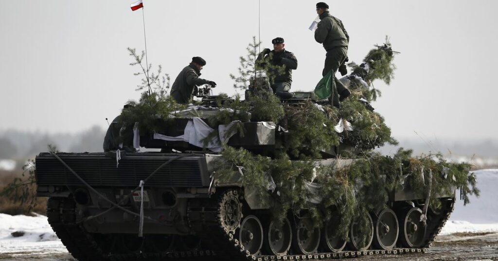 Polish army soldiers stay atop of their Leopard 2A4 tank after live firing exercise in Zagan