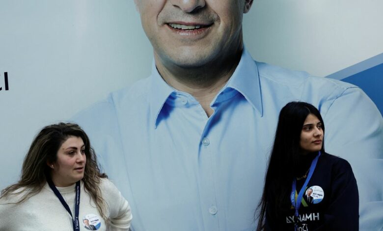 Supporters of Cyprus presidential candidate Nikos Christodoulides are seen in front of a poster in Nicosia