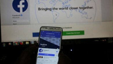 An illustration photo shows the Facebook page displayed on a mobile phone internet browser in front of a computer screen at a cyber-cafe in Nairobi, Kenya