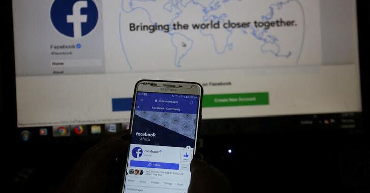 An illustration photo shows the Facebook page displayed on a mobile phone internet browser in front of a computer screen at a cyber-cafe in Nairobi, Kenya