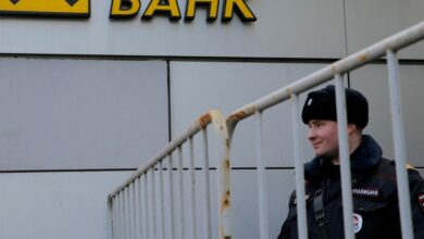 Russian police officer stands in front of branch of Raiffeisen Bank in Moscow