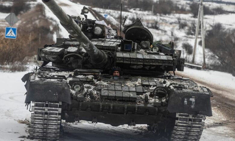 Ukrainian serviceman drives a tank along a road outside the frontline town of Bakhmut