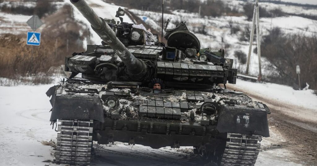 Ukrainian serviceman drives a tank along a road outside the frontline town of Bakhmut