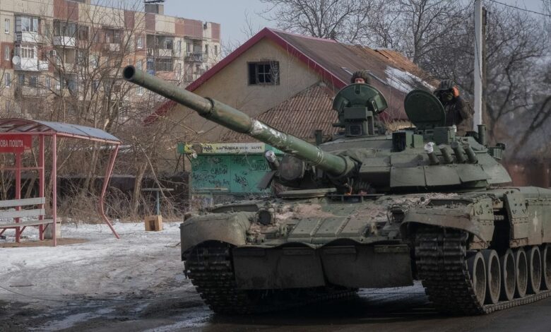 Ukrainian service members ride a tank in Bakhmut