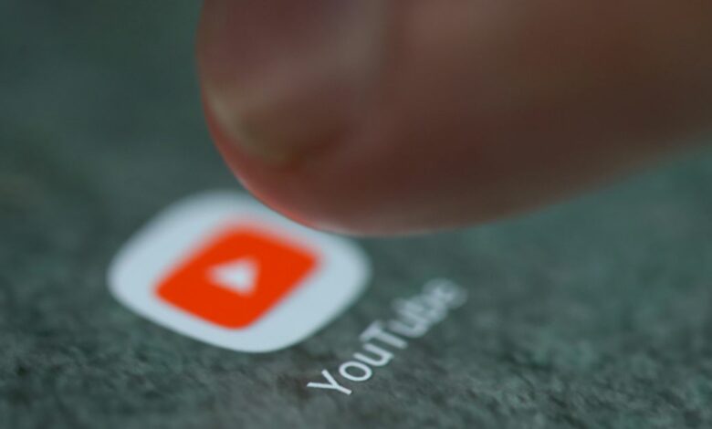 The YouTube app logo is seen on a smartphone in this illustration