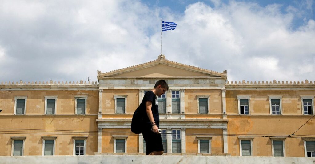 A man passes in front of the Greek parliament building in Athens