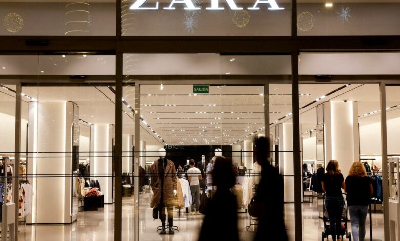 Shoppers walk past a Zara clothes store, part of the Spanish group Inditex
