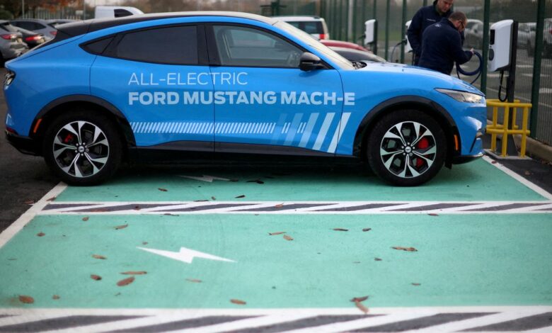 Workers plug in an electric Ford Mustang Mach-e electric vehicle during a press event at the Ford Halewood transmissions plant in Liverpool