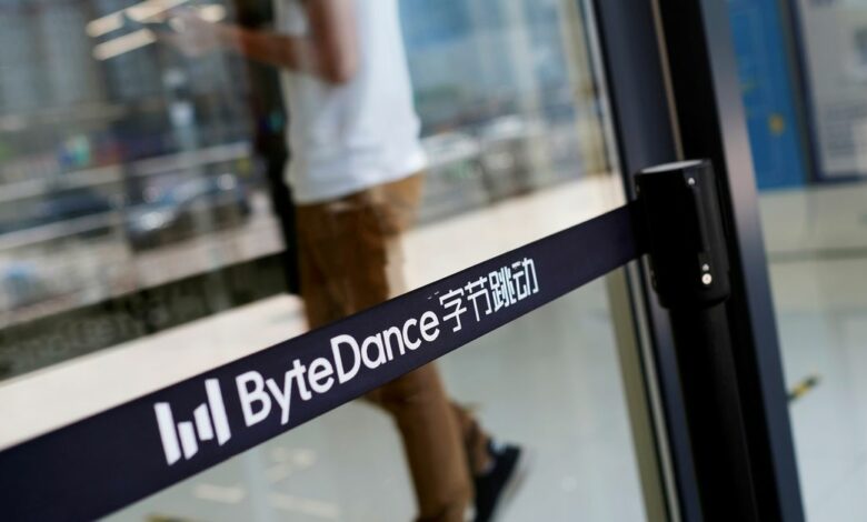 FILE PHOTO: Man walks by a logo of Bytedance, which owns short video app TikTok, at its office in Beijing