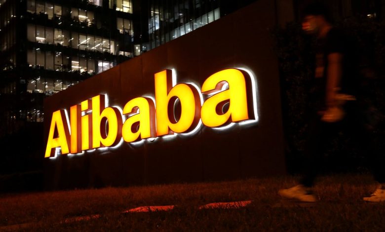 Man walks past a logo of Alibaba Group at its office building in Beijing
