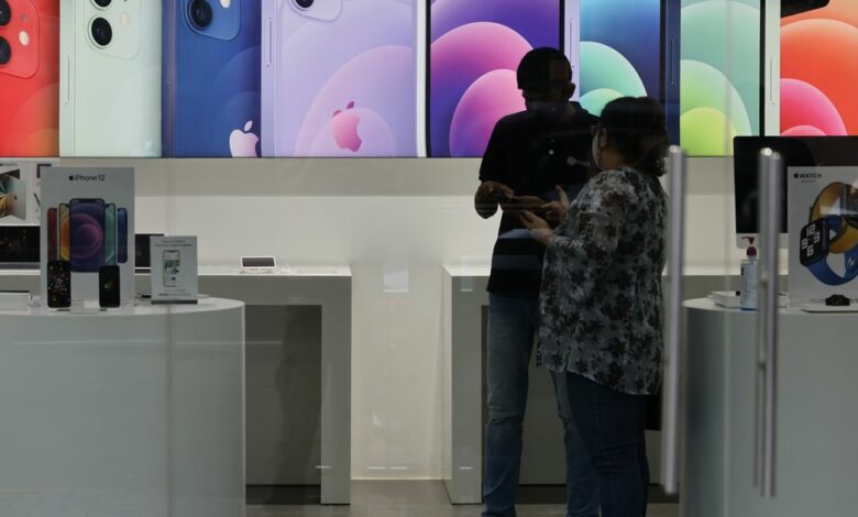 A salesperson speaks to a customer at an Apple reseller store in Mumbai