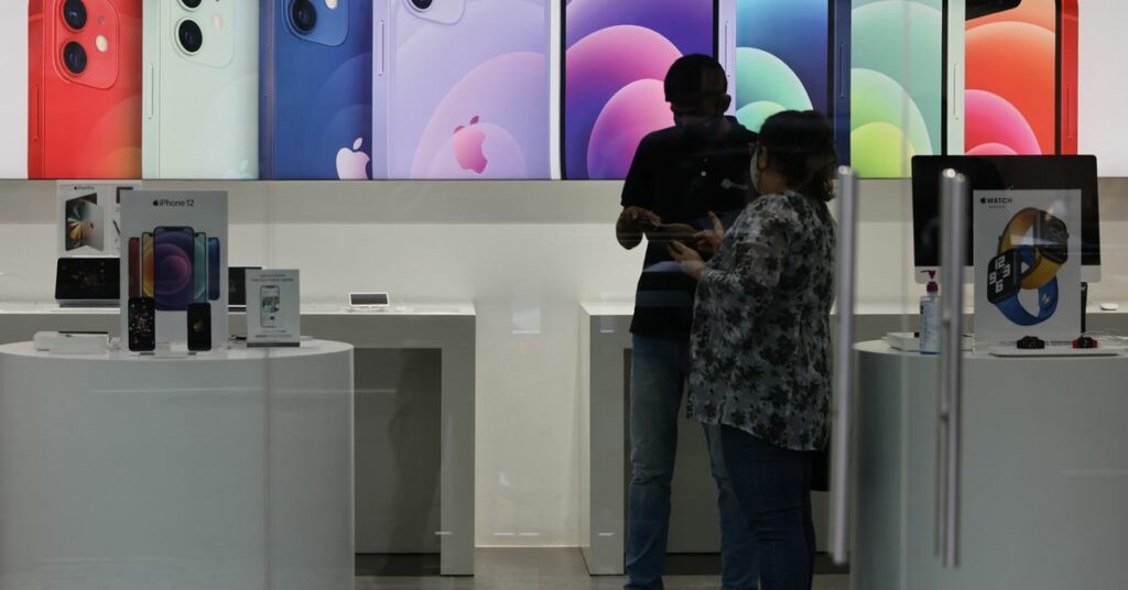 A salesperson speaks to a customer at an Apple reseller store in Mumbai
