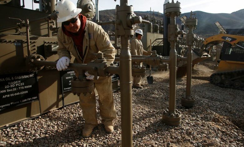Workers put the final touches on a natural gas well platform owned by Encana south of Parachute, Colorado