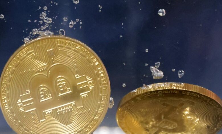Illustration shows representations of cryptocurrency Bitcoin plunging into water