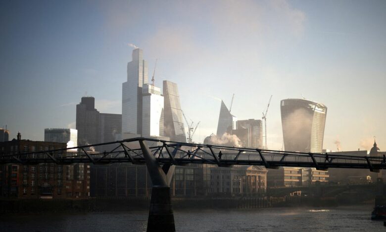 People walk over Millennium Bridge amidst early morning fog as the sun rises in London