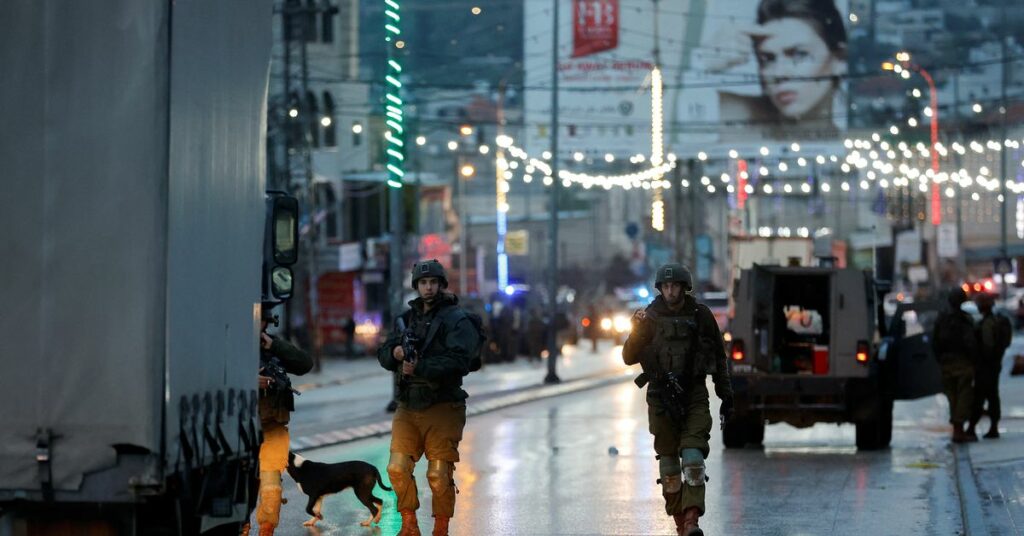 Israeli troops stand guard at a shooting scene in Huwara