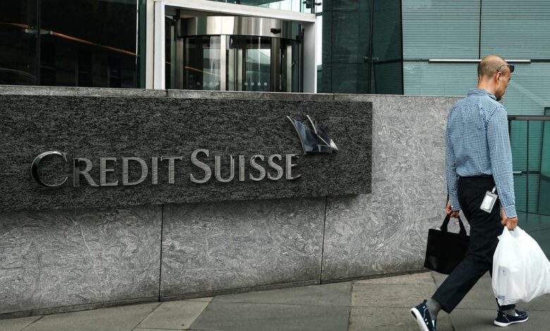 Pedestrian walks past a logo of Credit Suisse outside its office building in Hong Kong