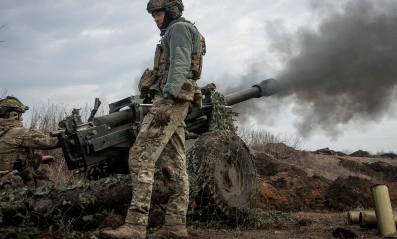 Ukrainian service members fire a howitzer M119 at a front line near Bakhmut
