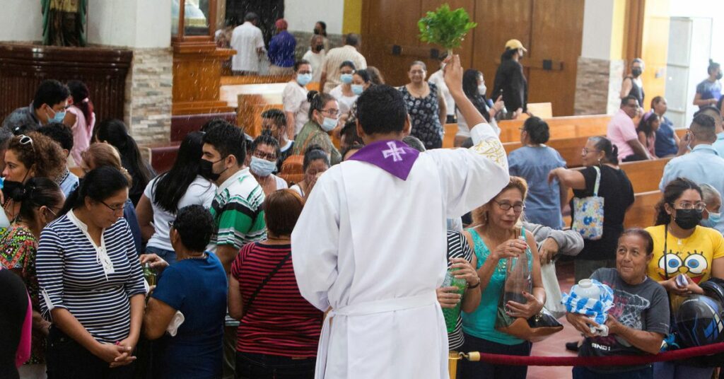 A bishop sprinkles water on the catholic parishioners at the Metropolitan Cathedral, in Managua