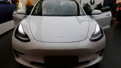 Visitors check a Tesla Model 3 car at a showroom of the U.S. electric vehicle maker in Beijing, China