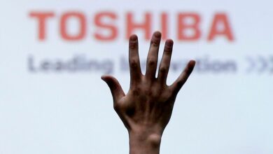 A reporter raises his hand for a question during a news conference by Toshiba Corp CEO Satoshi Tsunakawa at the company headquarters in Tokyo