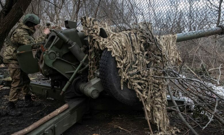 A Ukrainian service member prepares to shoot from a howitzer at a front line near the city of Bakhmut