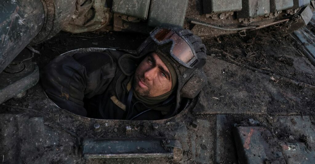 Ukrainian serviceman looks on before driving a tank near the frontline town of Bakhmut