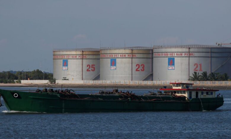 A vessel sails near PetroVietnam oil tanks in Vung Tau