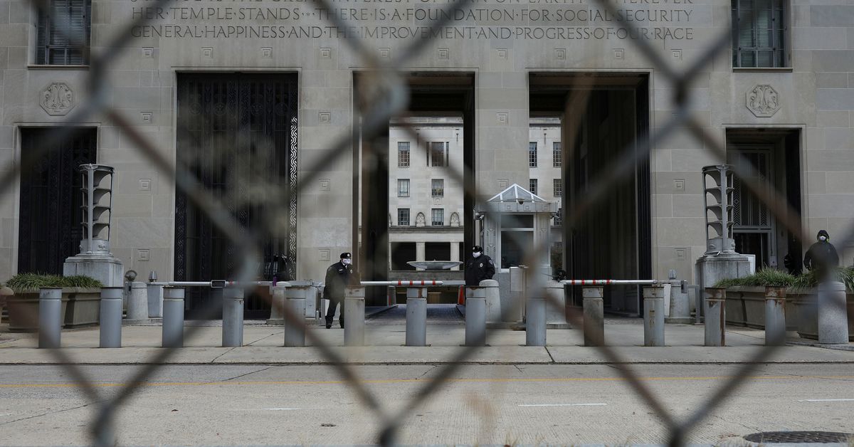Security officers stand guard outside of the U.S. Department of Justice Building in Washington