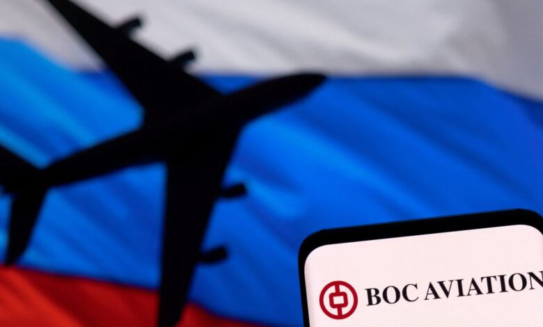 Illustration shows BOC Aviation logo displayed in front of the model of an airplane and a Russian flag