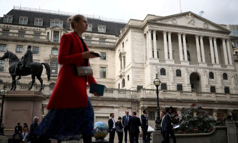 People stand outside the Bank of England in the City of London financial in London