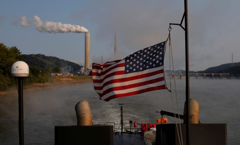 The U.S. flag flies on a towboat as it passes the W. H. Sammis Power Plant along the Ohio River in Stratton