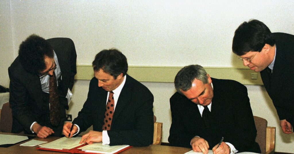 British Prime Minister Tony Blair (L) and Irish Prime Minister Bertie Ahern sign the peace agreement..