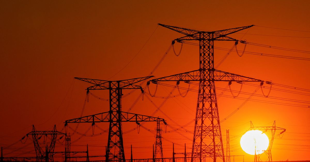 Electricity pylons of high-voltage electrical power lines are seen during sunset, in Gavrelle