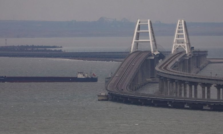 A cargo ship sails next to the Crimea bridge in the Kerch Strait