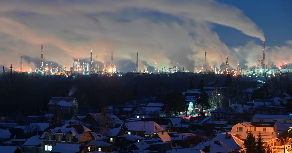 Flue gas and steam rise out of chimneys of an oil refinery in Omsk